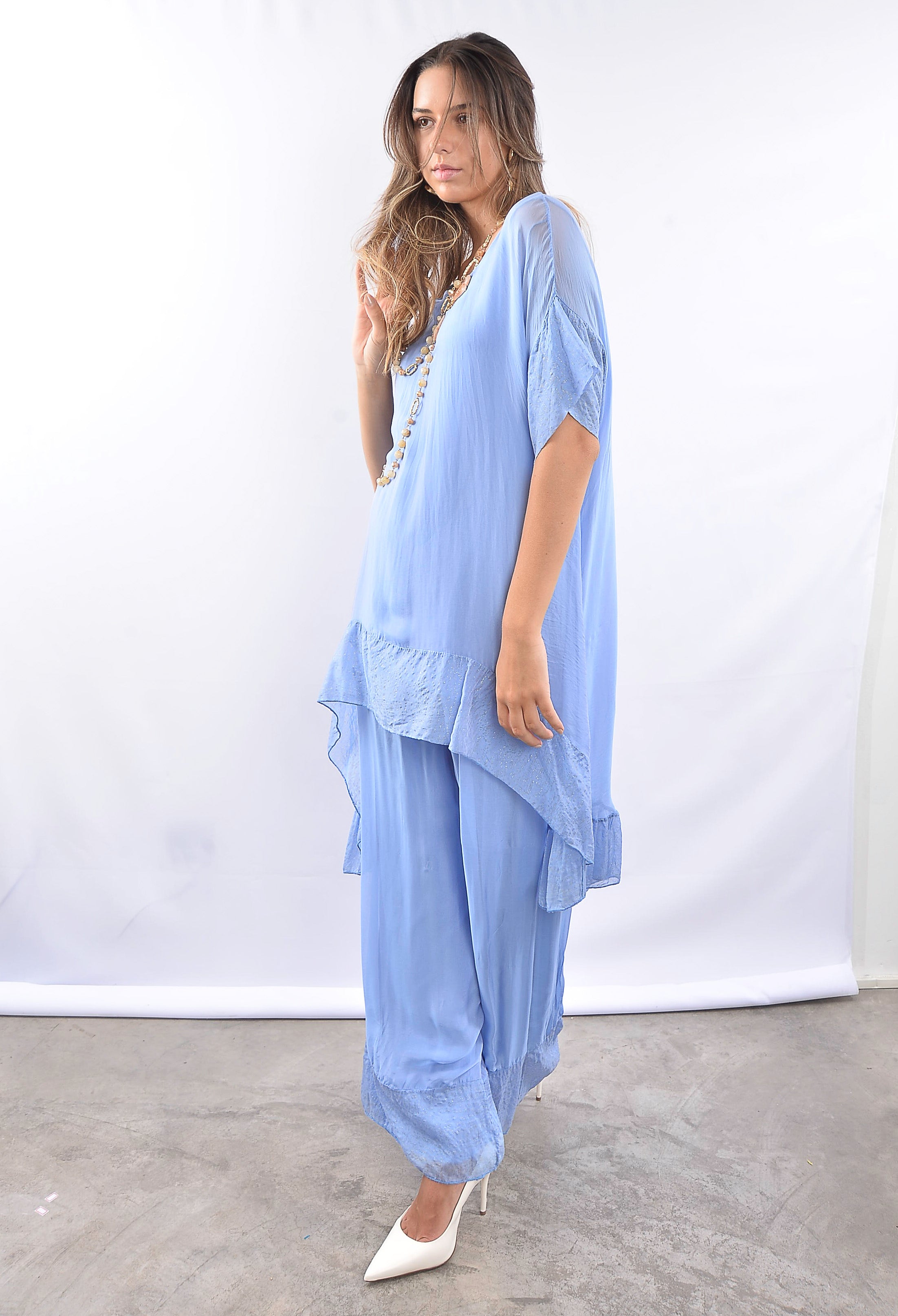 Conjunto feminino azul em tecido fluido, visto de lado.