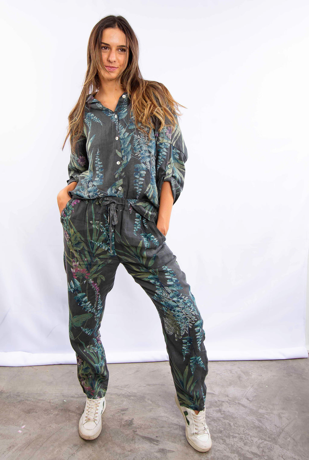 Mulher vestindo conjunto estampado azul com calça e blusa de manga longa, em pose frontal.