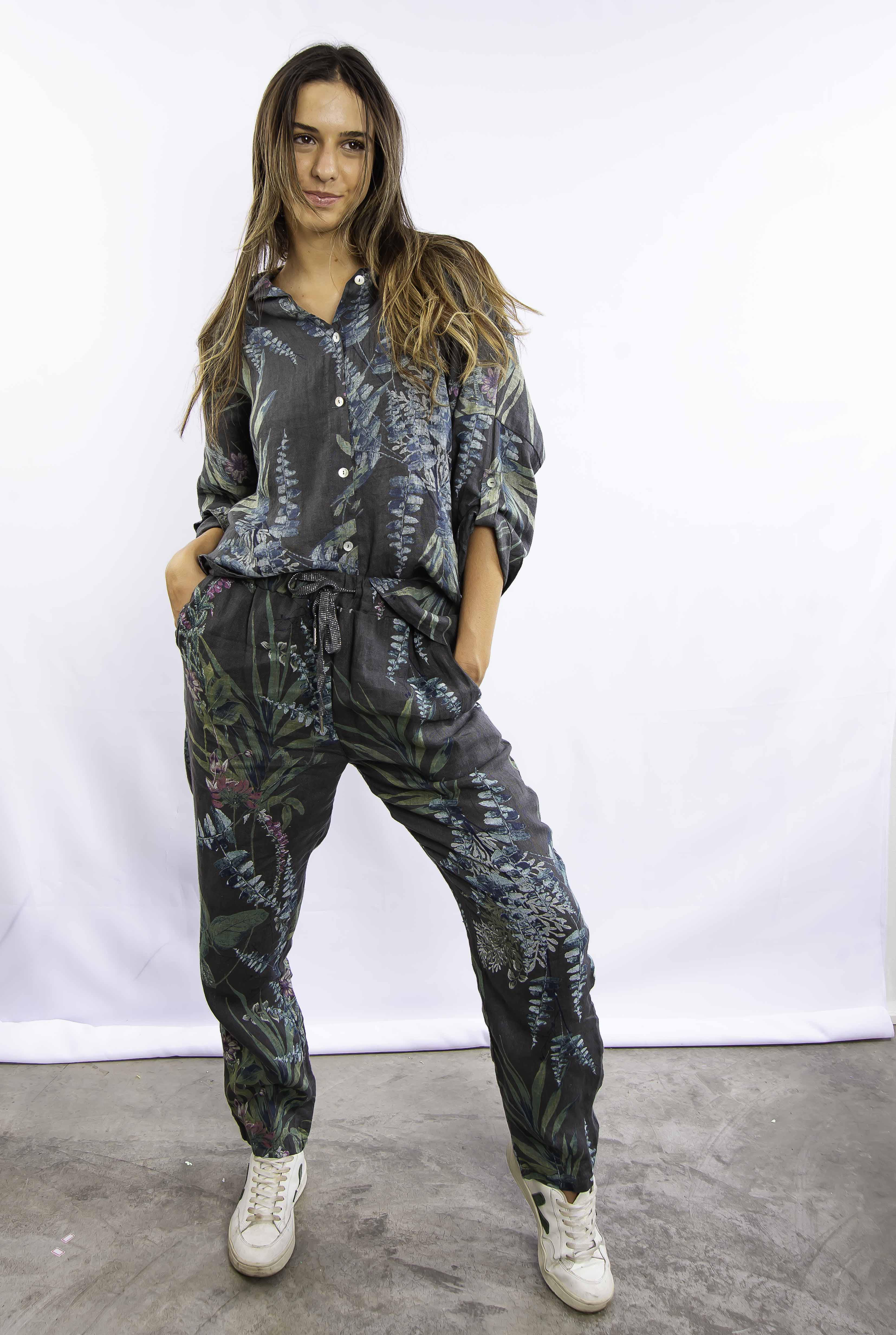 Mulher vestindo conjunto estampado azul com calça e blusa de manga longa, em pose frontal.
