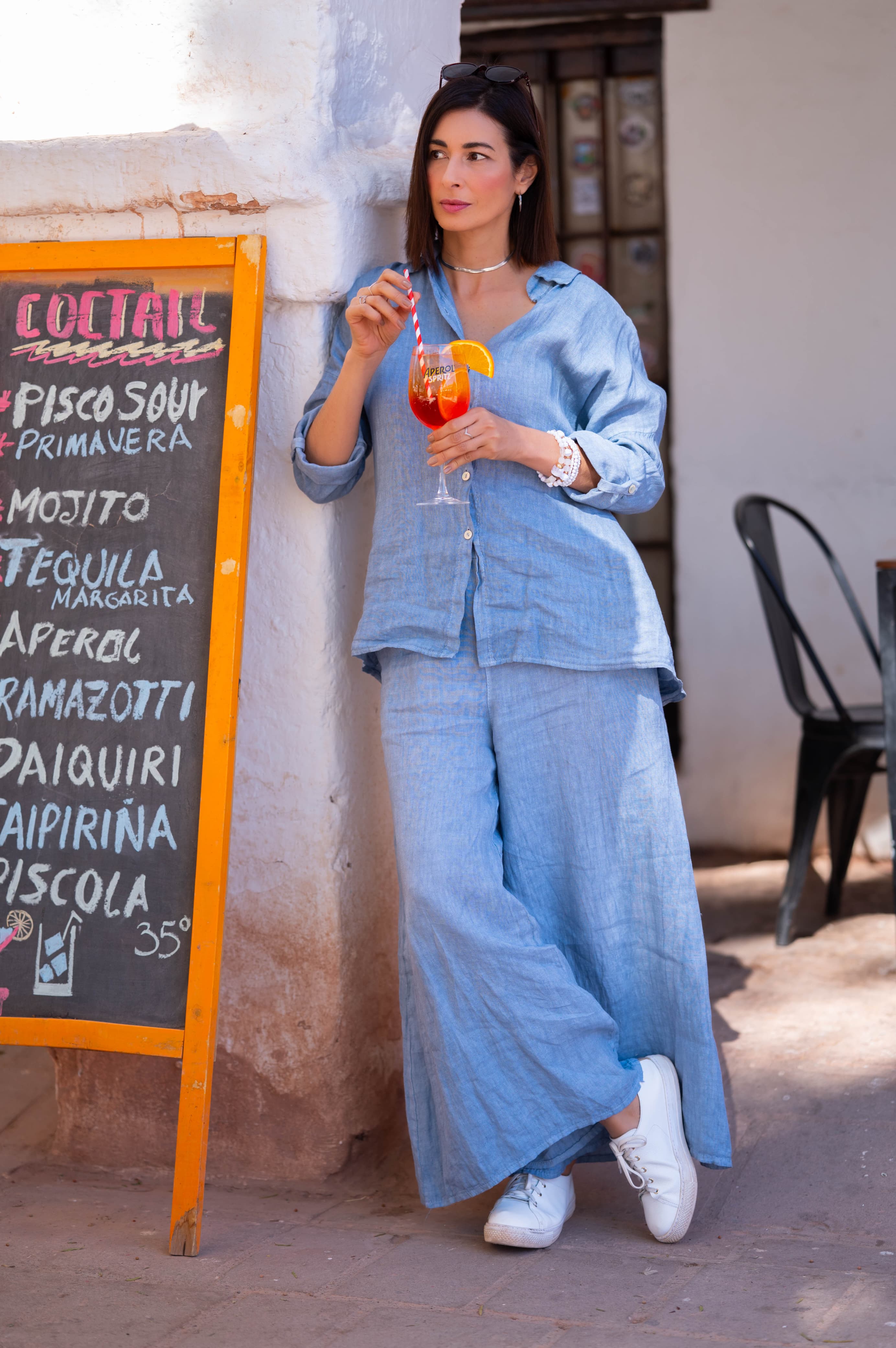 Mulher usando conjunto azul de linho italiano em estilo casual ao ar livre.