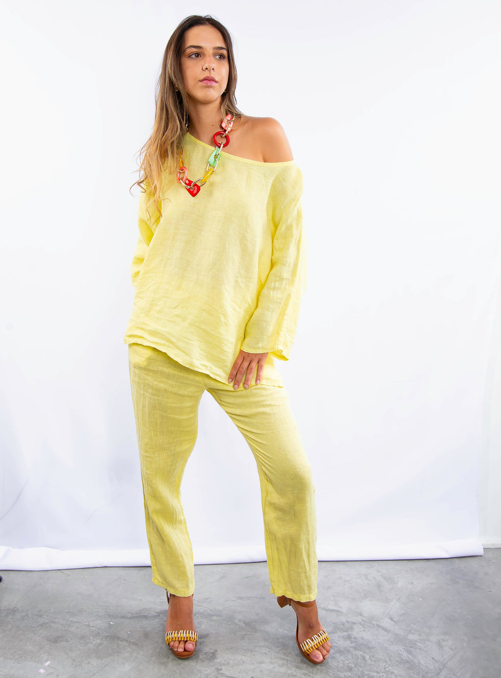 Modelo usando conjunto feminino de linho italiano amarelo com blusa oversized e calça reta.