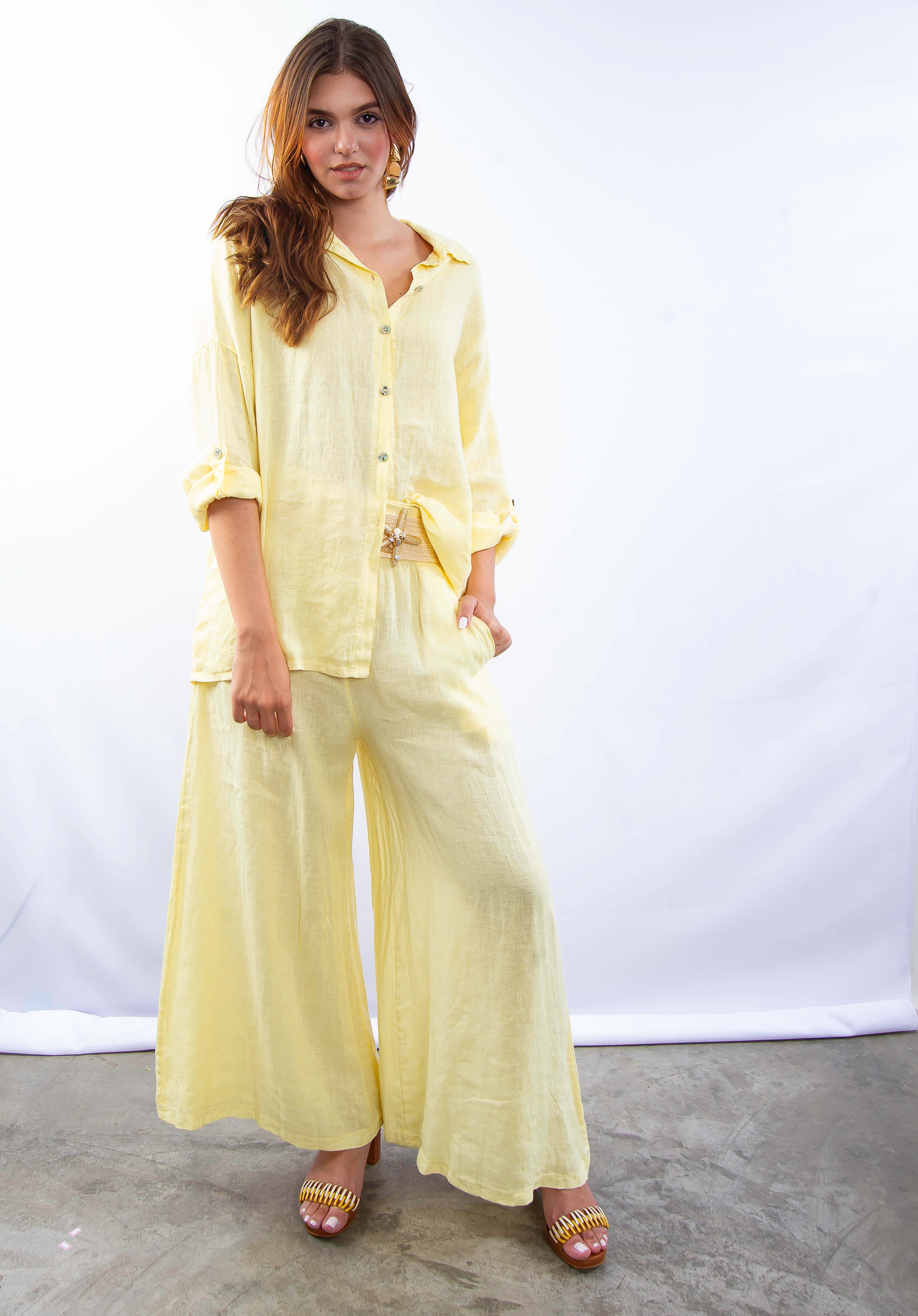 Mulher usando conjunto de linho italiano amarelo, vista de frente com blusa longa e calça fluida.