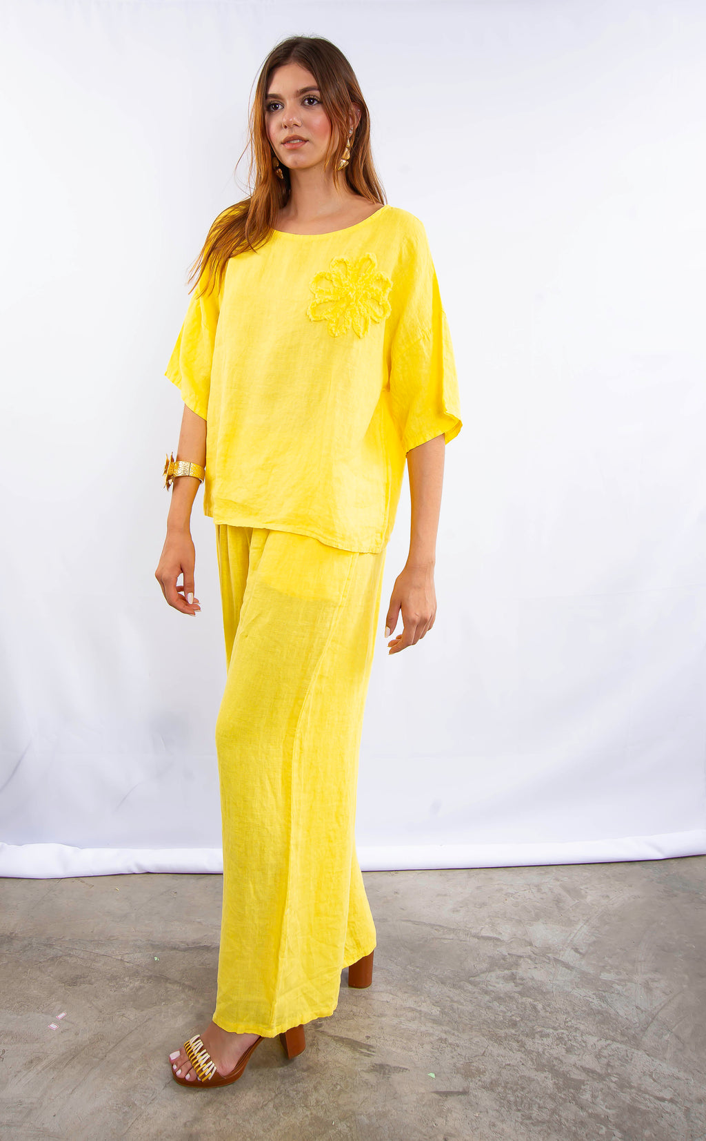 Modelo usando conjunto de linho italiano amarelo com blusa solta e calça pantalona.