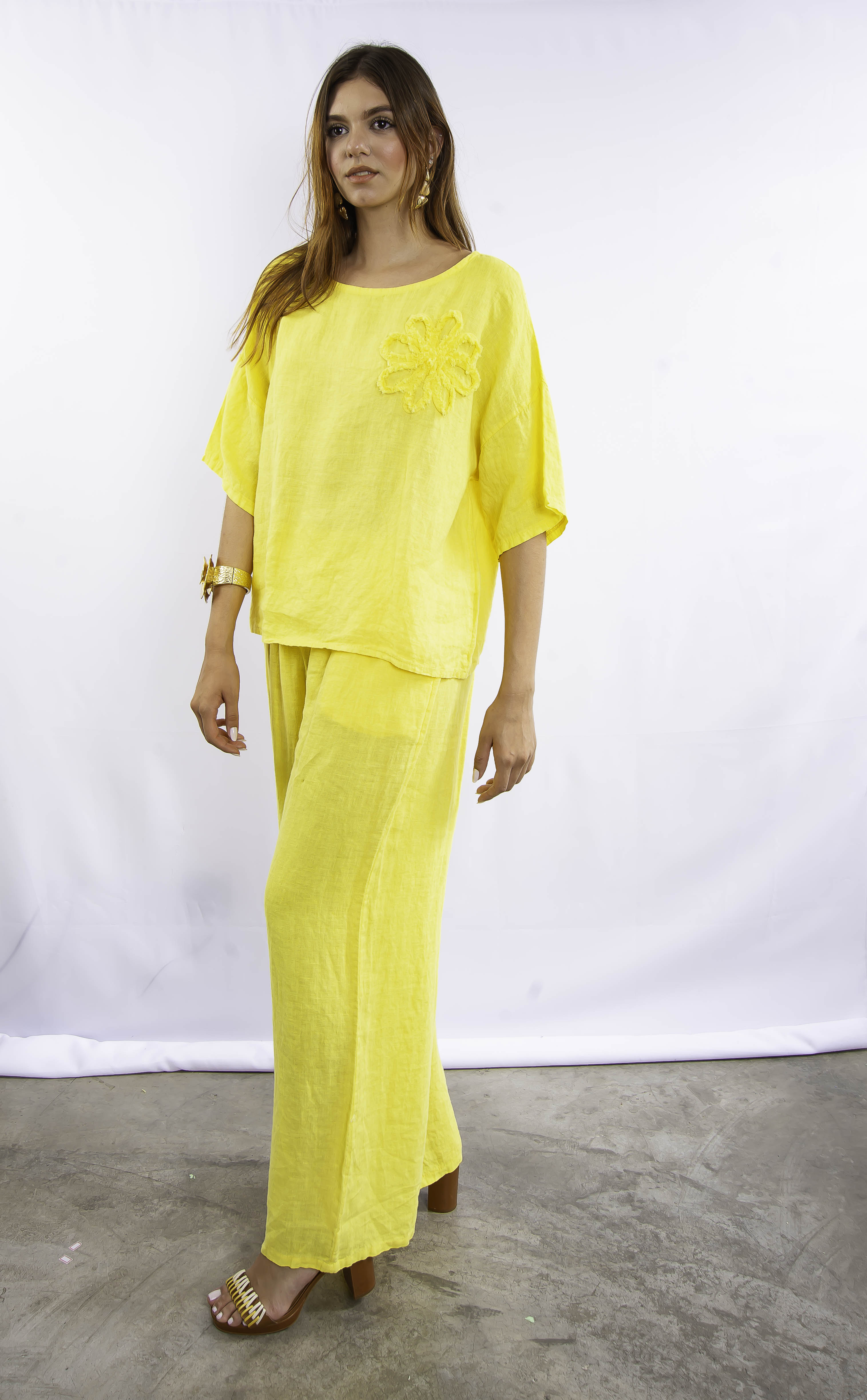 Modelo usando conjunto de linho italiano amarelo com blusa solta e calça pantalona.