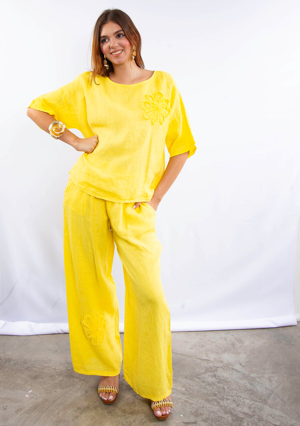 Conjunto de linho italiano amarelo, modelo em pose lateral destacando fluidez do tecido.