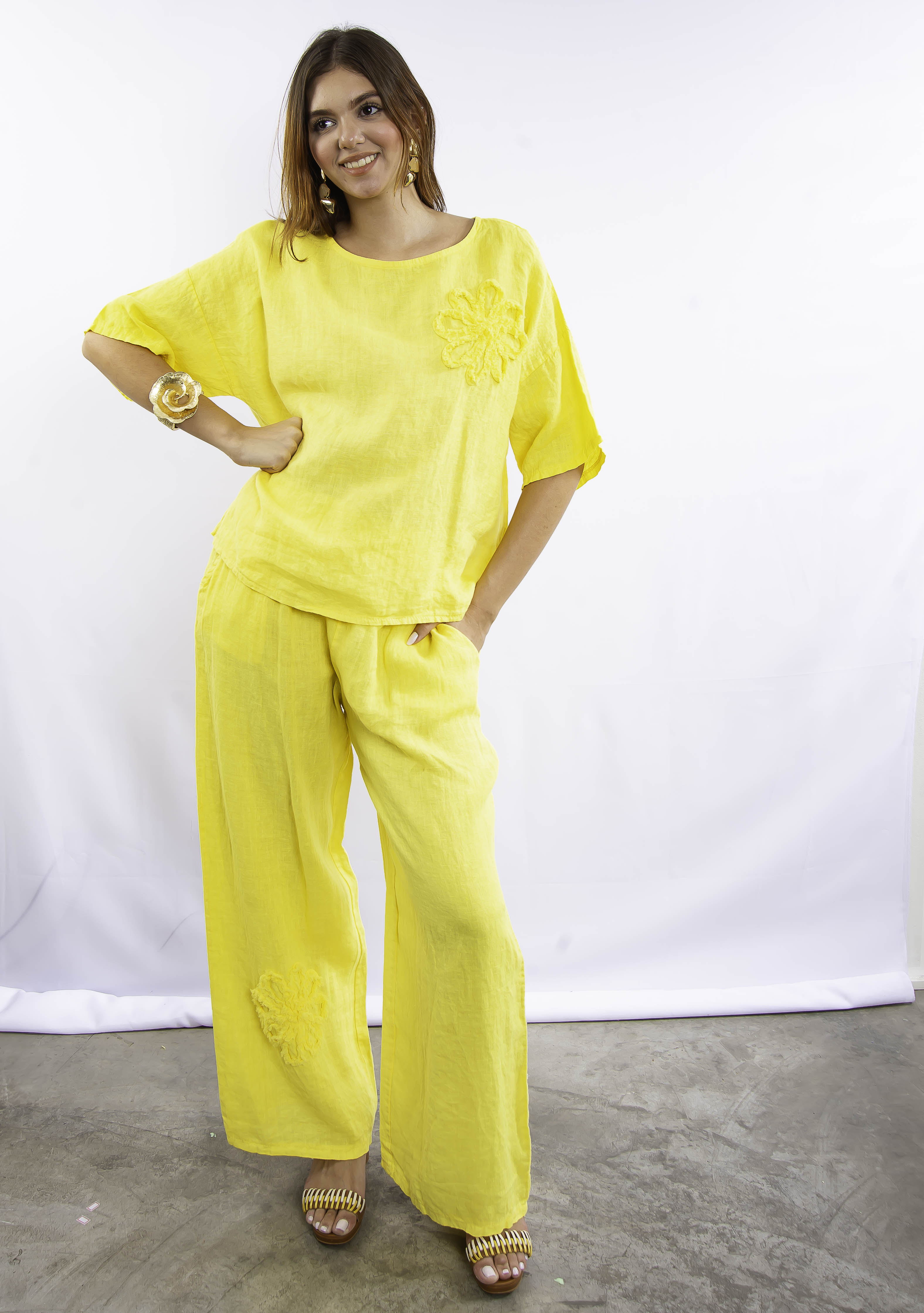Conjunto de linho italiano amarelo, modelo em pose lateral destacando fluidez do tecido.
