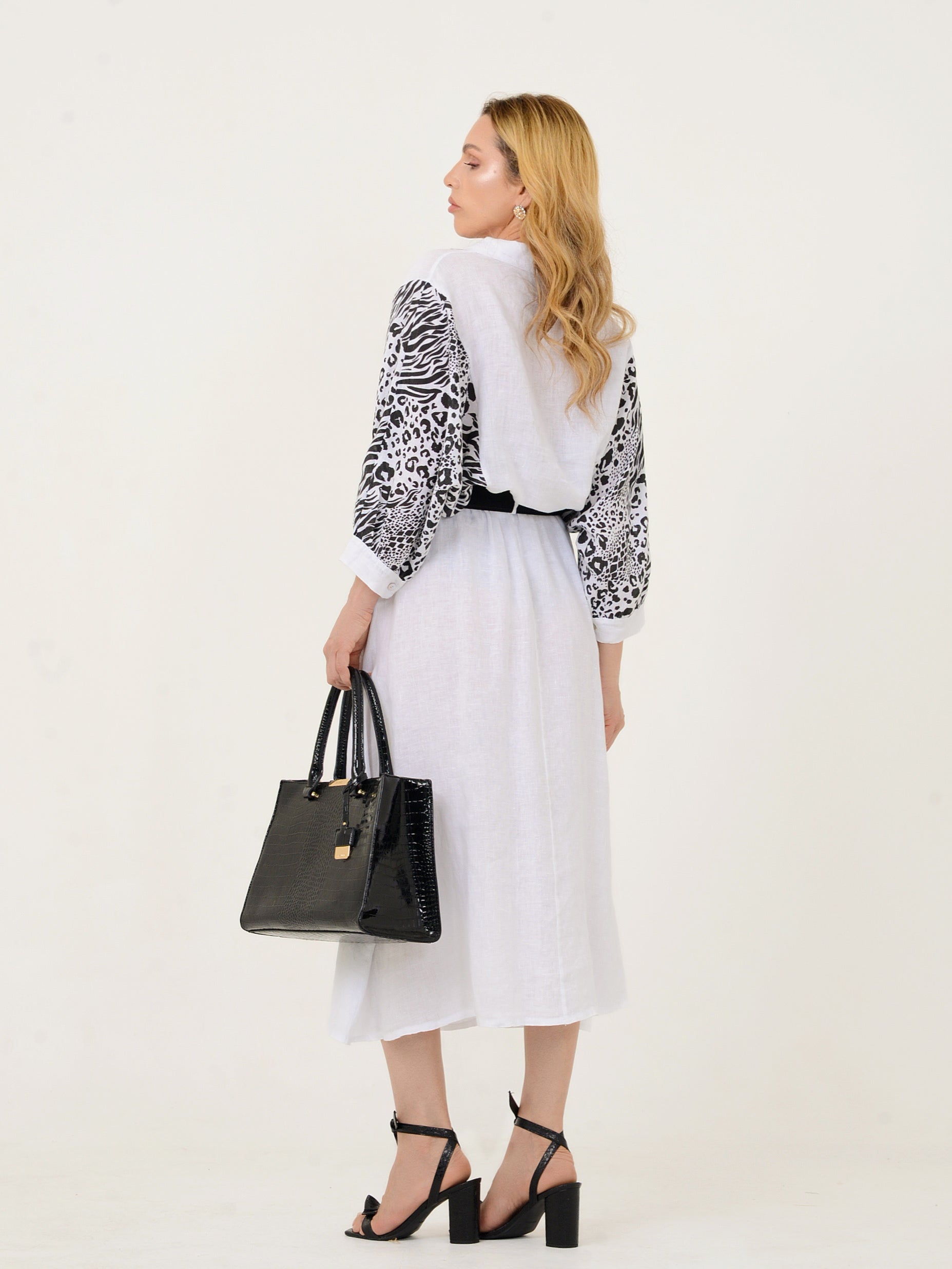 Mulher usando conjunto midi branco com mangas estampadas vista de costas.