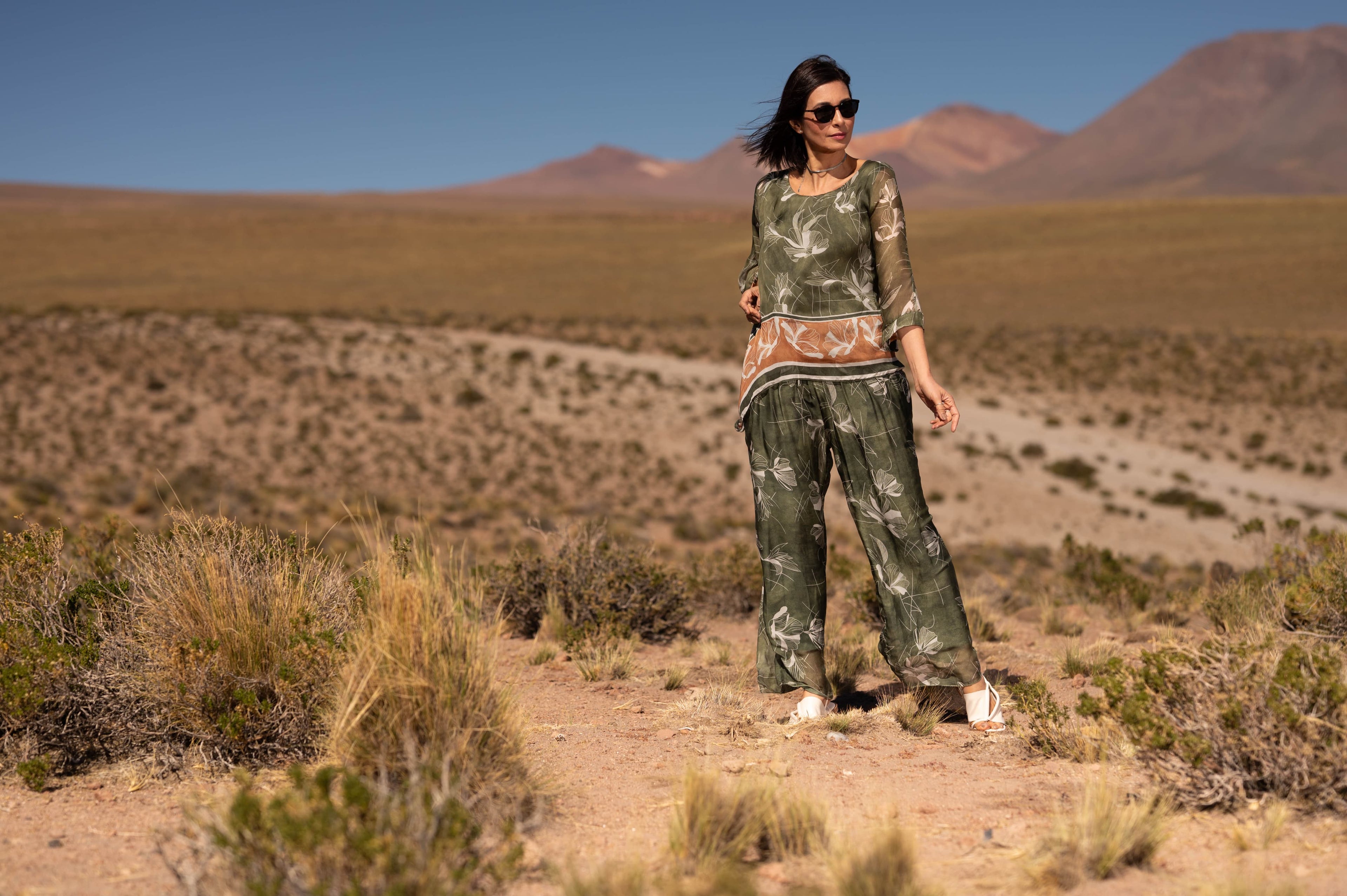 Mulher usando Conjunto Puglia verde em viscose e seda em cenário desértico.