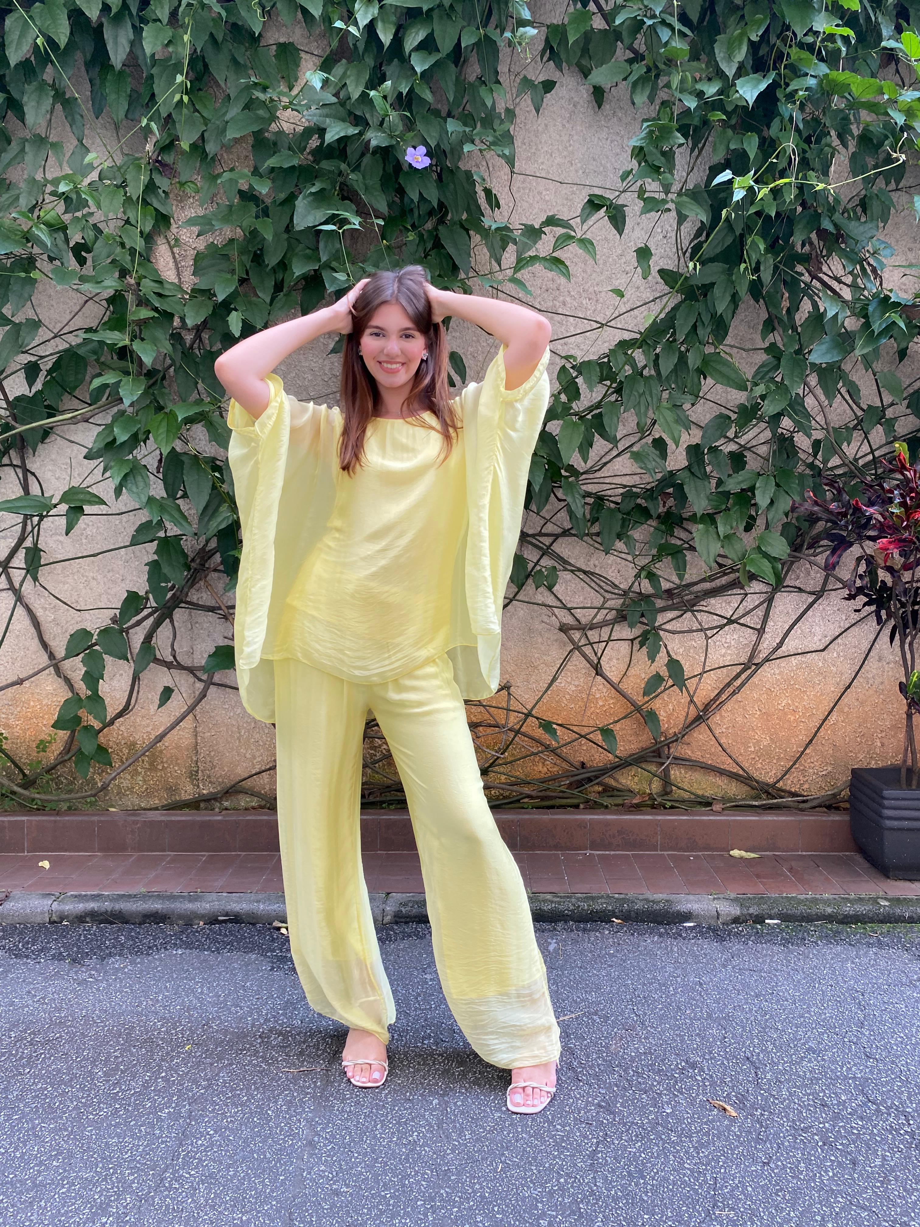 Mulher vestindo Conjunto Sicília em viscose e seda italiana amarelo, com caimento leve e elegante.