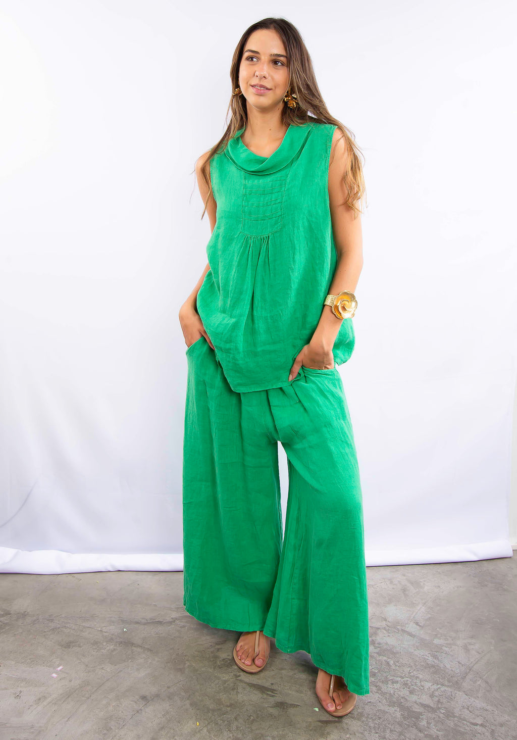 Mulher usando conjunto verde em linho, composto por blusa sem mangas e calça pantalona.