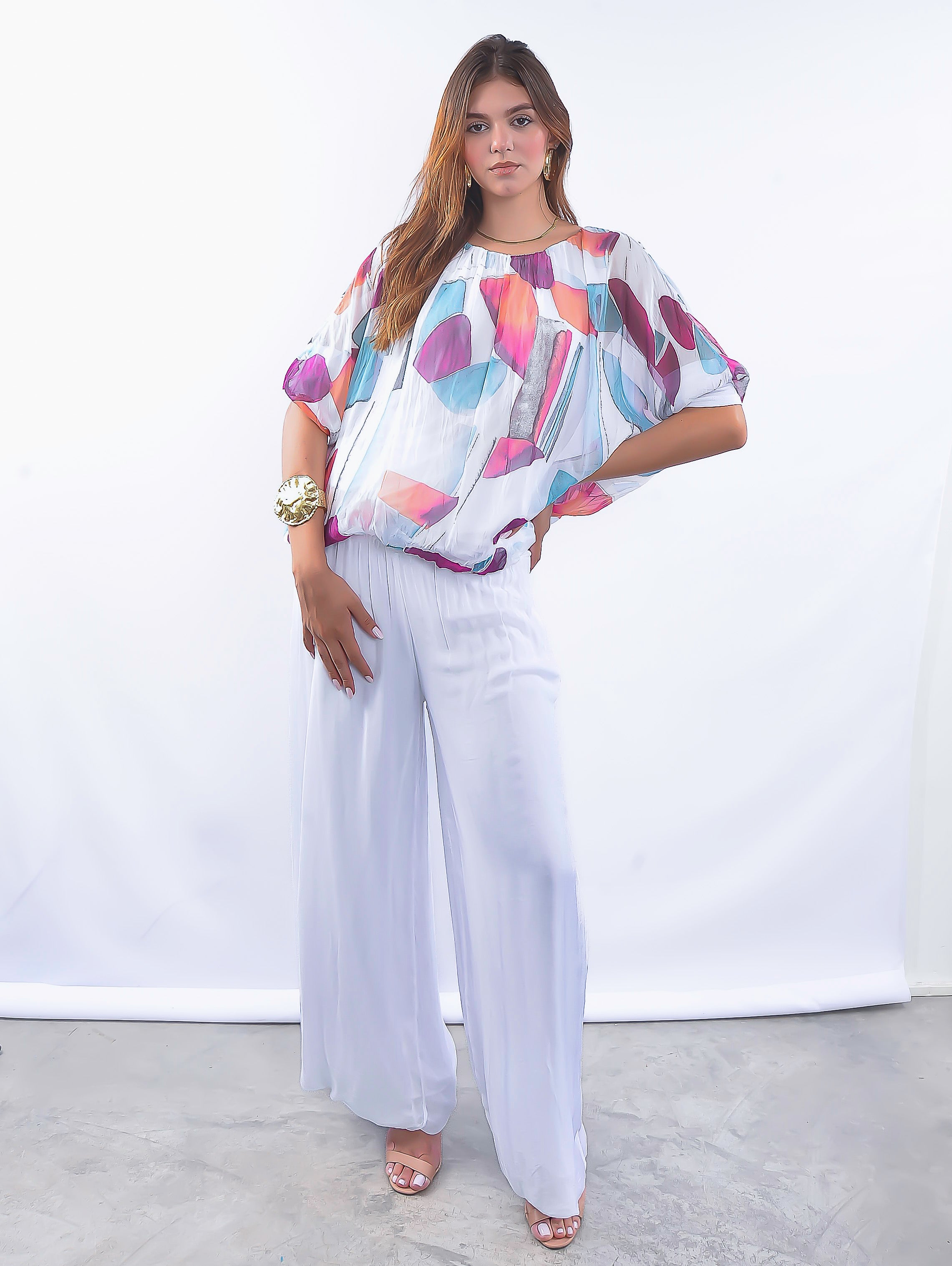 Look feminino sofisticado com blusa soltinha em seda estampada e calça ampla.