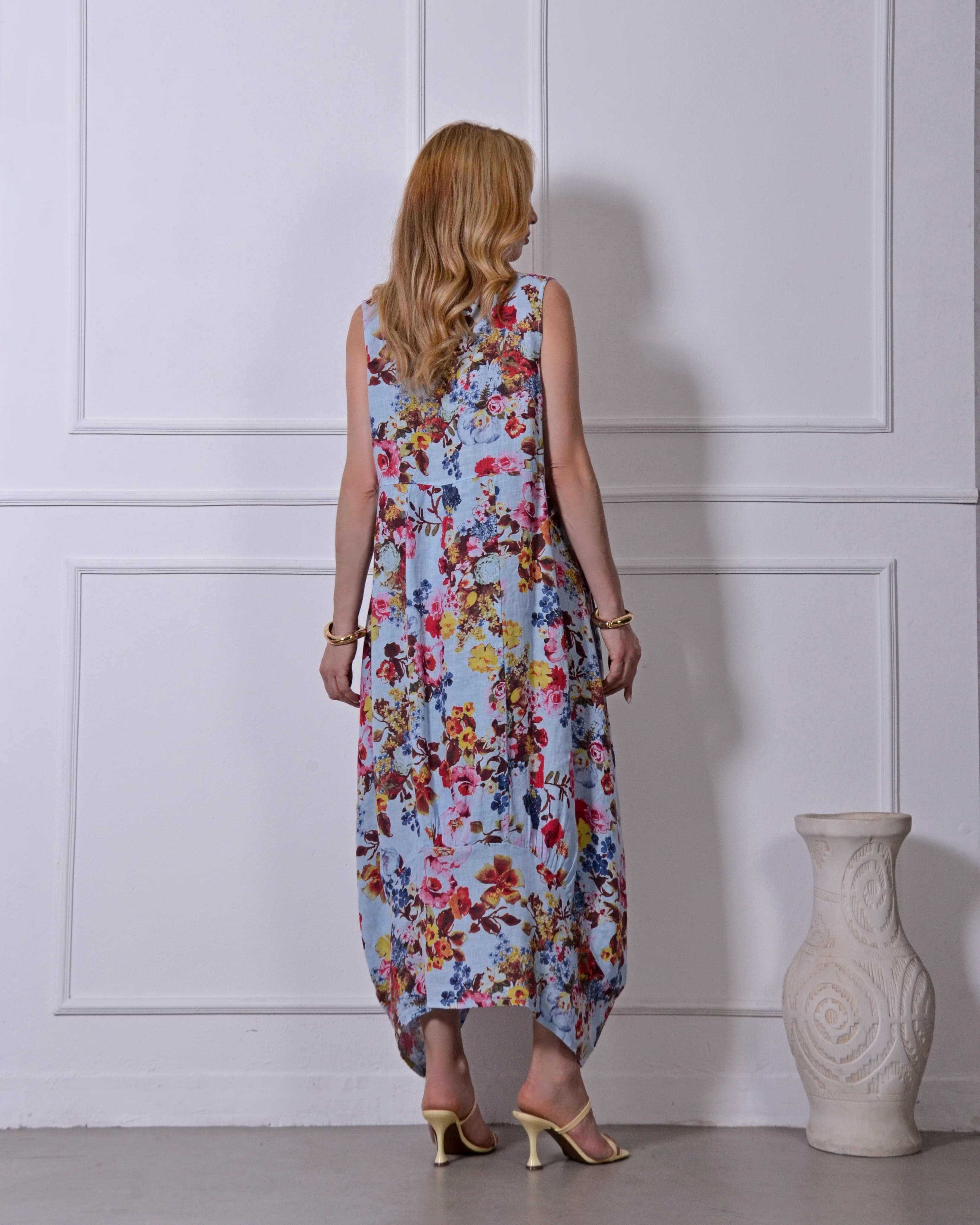 Modelo em vestido longo floral colorido posando de lado.