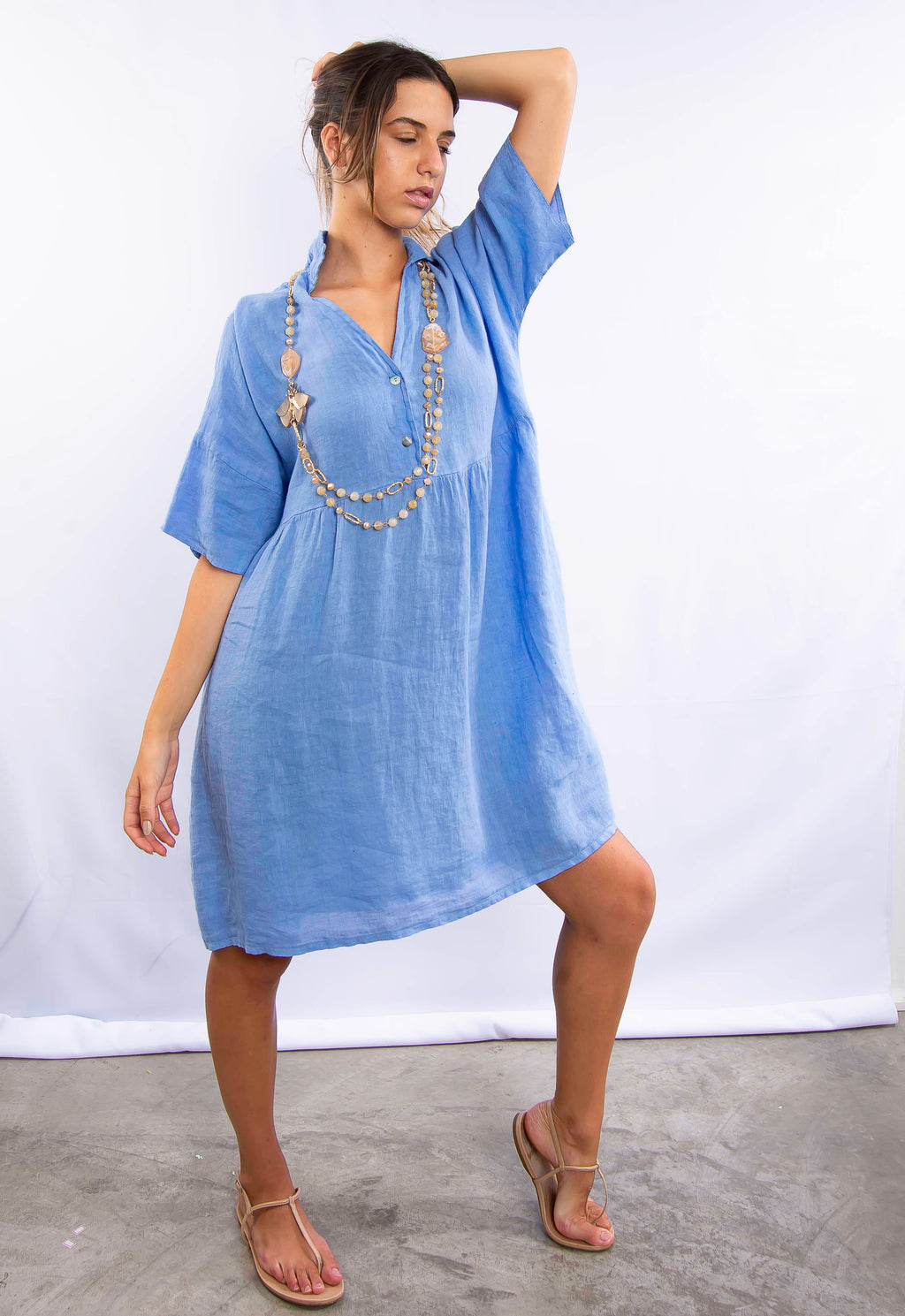 Vestido jeans azul com mangas soltas em modelo casual.