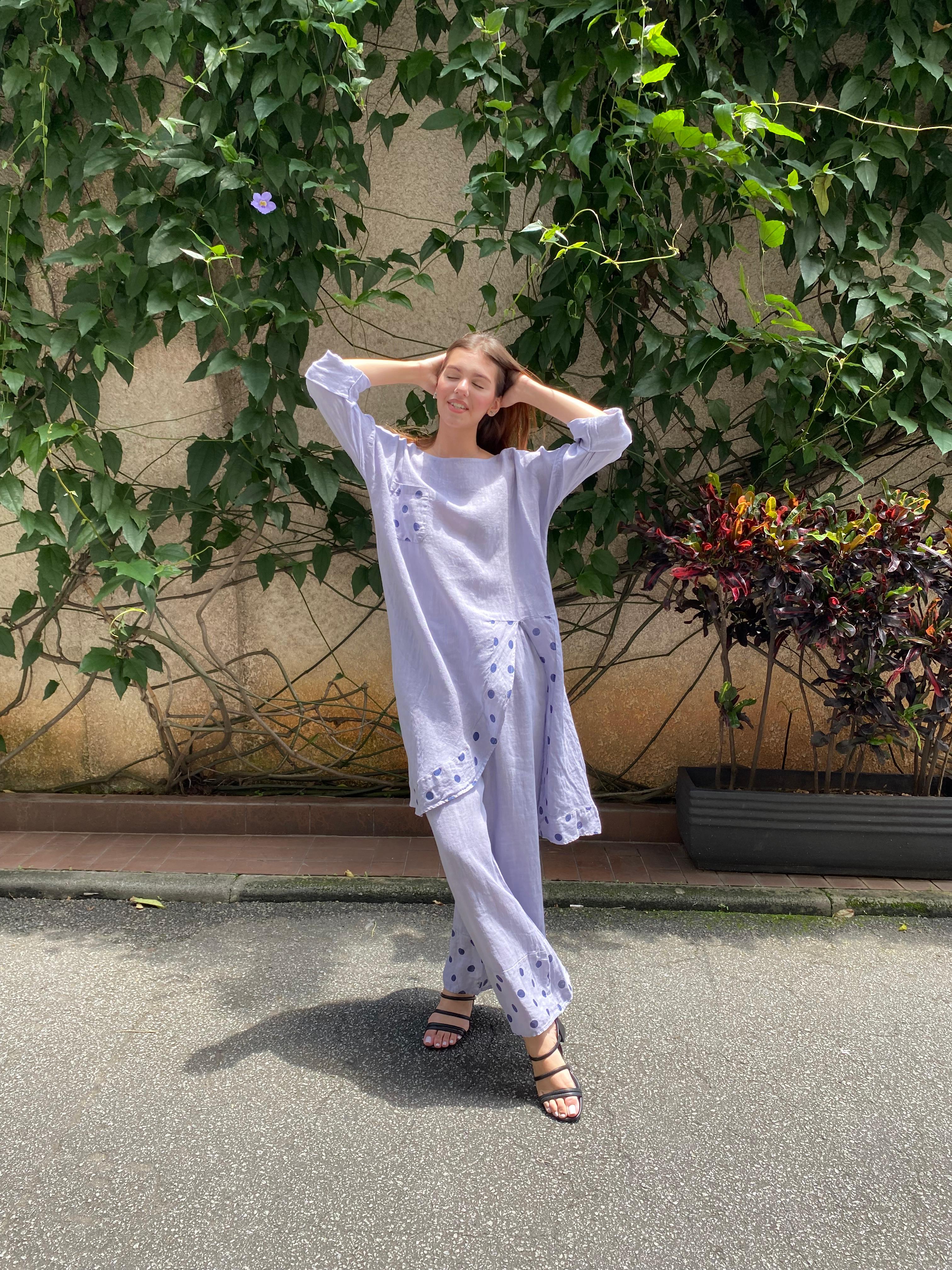 Mulher usando vestido longo lavanda de linho italiano em área externa.