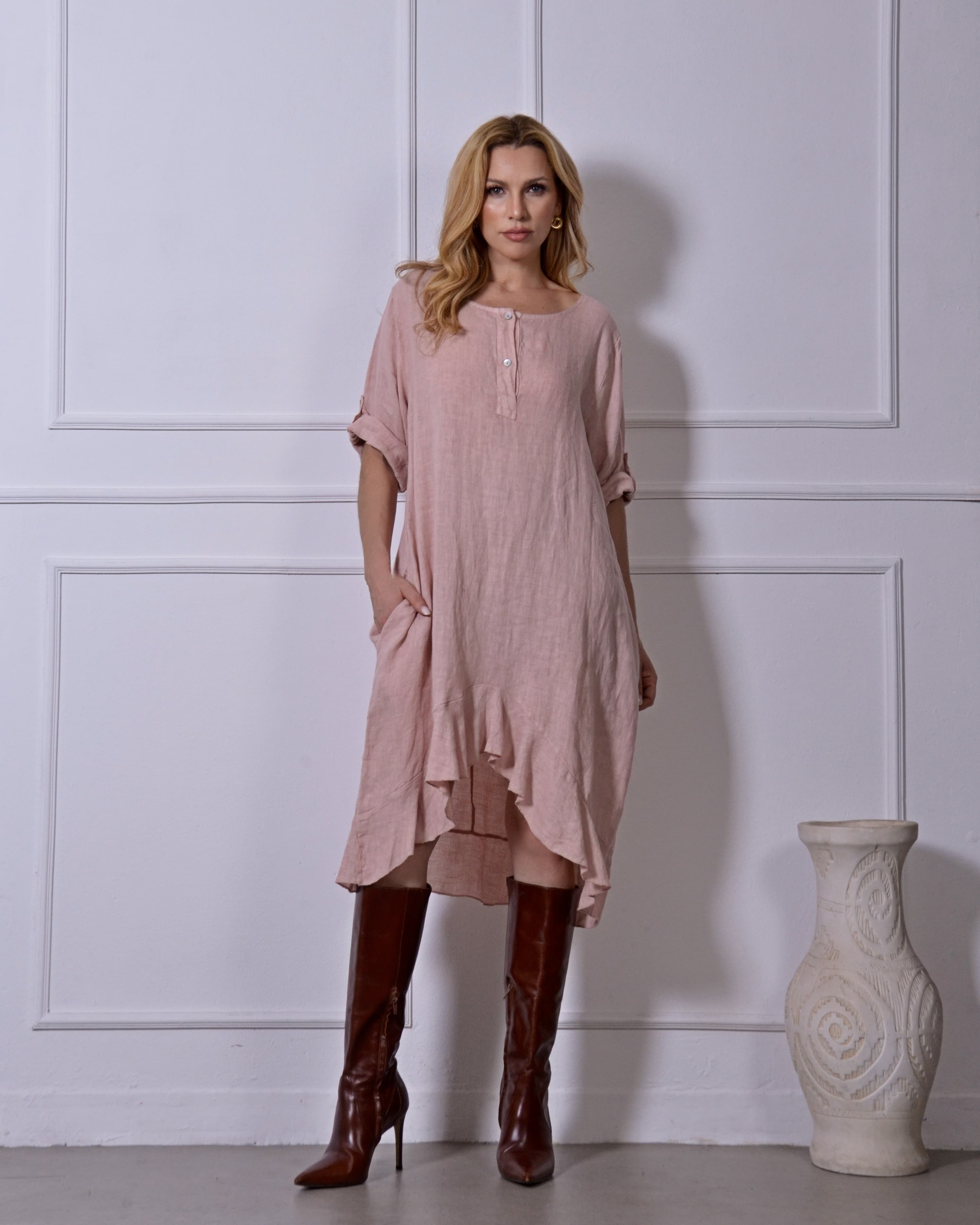 Mulher usando vestido rosa em linho, vista frontal com detalhe fluido.