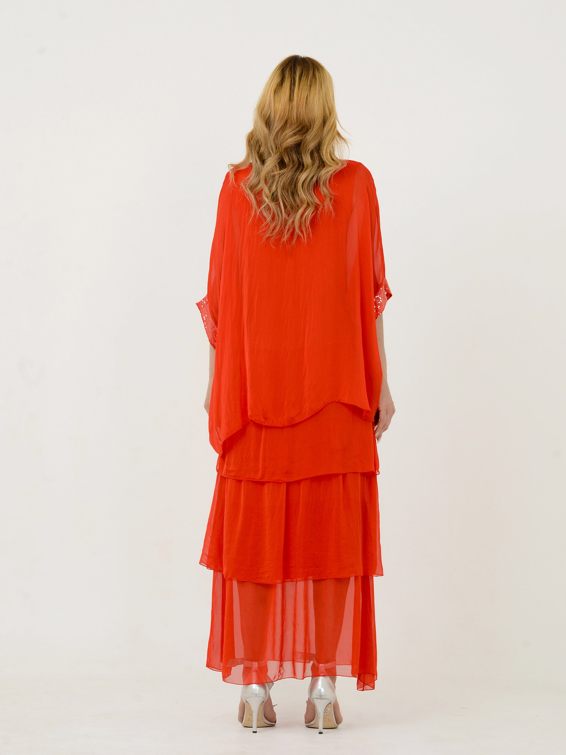 Mulher de costas usando vestido vermelho em camadas elegante.