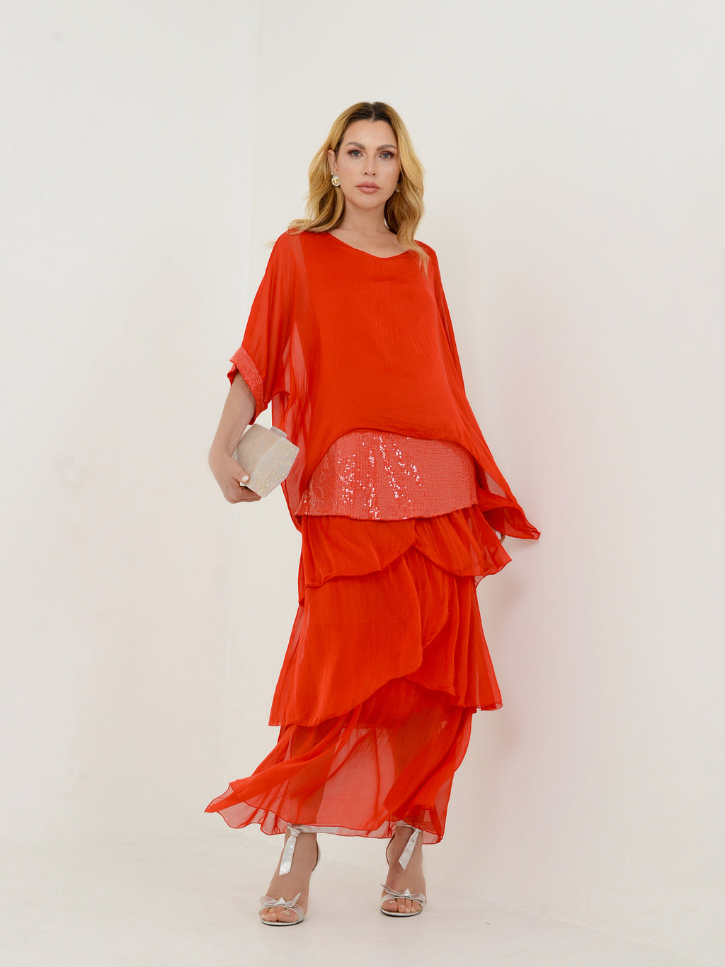 Mulher usando vestido vermelho em camadas visto de frente.