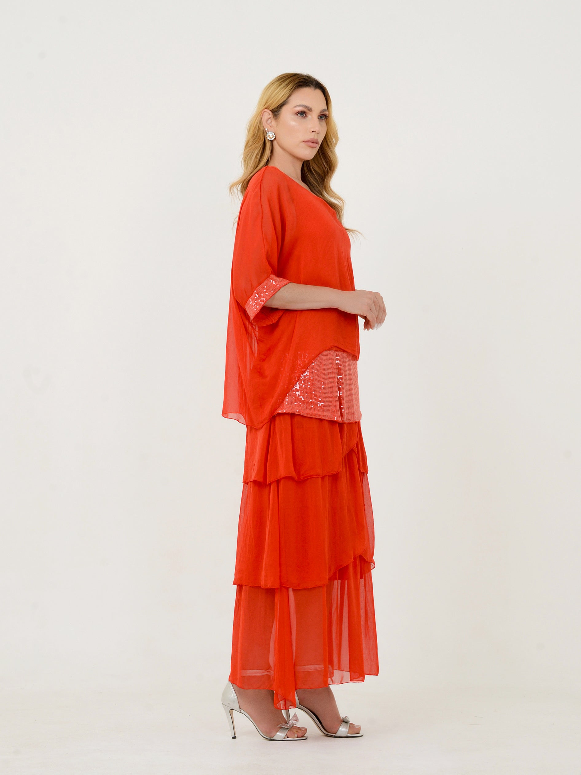 Vestido vermelho em camadas fotografado de perfil.